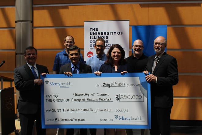 Javon R. Bea, president and CEO of Mercyhealth (far left), and Dr. Alex Stagnaro-Green, regional dean, University of Illinois College of Medicine Rockford (far right), pose for photos on July 19, 2017, at a check presentation event with UIC expansion faculty. [PHOTO PROVIDED]