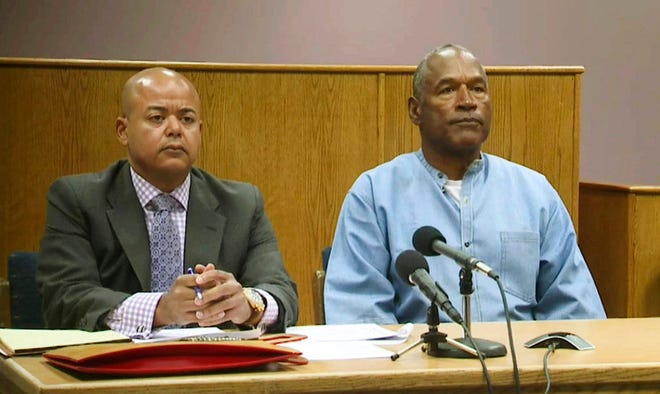 Former NFL football star O.J. Simpson appears with his attorney, Malcolm LaVergne, left, via video for his parole hearing at the Lovelock Correctional Center in Lovelock, Nev., on Thursday, July 20, 2017. Simpson was convicted in 2008 of enlisting some men he barely knew, including two who had guns, to retrieve from two sports collectibles sellers some items that Simpson said were stolen from him a decade earlier. (Lovelock Correctional Center via AP)