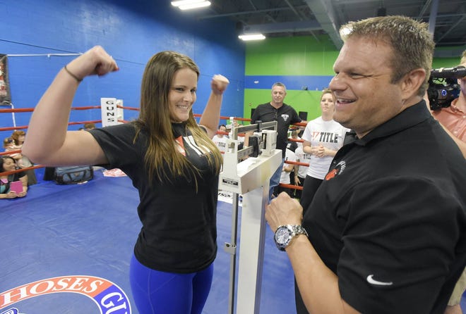 Bob.Self@jacksonville.com—4/14/15—Fighter Erin Filbert representing the Fraternal Order of Police flexes at the ceremonial weigh in with event coordinator Alex Bergamo Tuesday evening. Fighters for the upcoming 16th. Annual Guns ‘N Hoses fight between firefighters and law enforcement posed for photographs in the ring at Rebounderz off Old St. Augustine Road Tuesday evening. The April 18th. event will be feature 15 bouts including two with female fighters. (The Florida Times-Union/Bob Self)