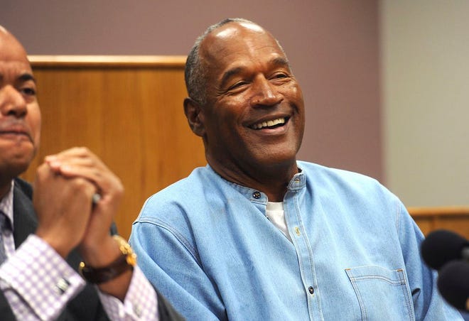 Former NFL football star O.J. Simpson laughs as he appears via video for his parole hearing at the Lovelock Correctional Center in Lovelock, Nev., on Thursday, July 20, 2017. Simpson was granted parole Thursday after more than eight years in prison for a Las Vegas hotel heist, successfully making his case in a nationally televised hearing that reflected America's enduring fascination with the former football star. (Jason Bean/The Reno Gazette-Journal via AP, Pool)