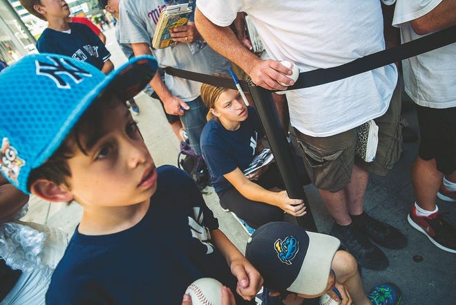 Caitlin Springer, 15, crouches down while hoping to catch her hero, Aaron Judge, as New York Yankees autograph seekers wait patiently in front of the Grand Hotel in Minneapolis as players exit to board a bus to head to Target Field for a game against the Minnesota Twins on July 17. Richard Tsong-Taatarii/Minneapolis Star Tribune/TNS