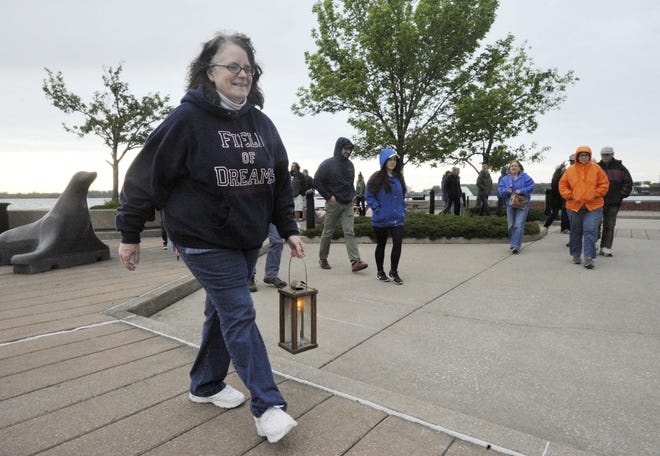 Stephanie Wincik leads a candlelight tour of local history and legends around lower State Street and Dobbins Landing in Erie on May 26. Walks are set for Friday and Saturday and continue through October. [GREG WOHLFORD FILE PHOTO/ERIE TIMES-NEWS]