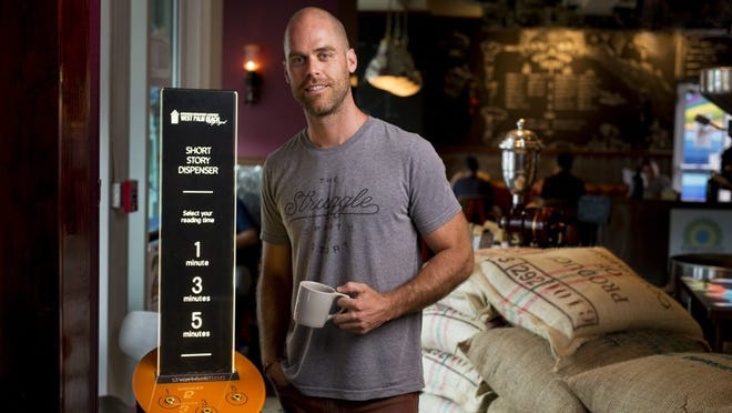 Sean Scott stands with a new short story dispenser inside Subculture Coffee in downtown West Palm Beach on June 27, 2017. The West Palm Beach Downtown Development Authority has installed the dispenser, which prints out 1-3 minute free stories on paper, with plans to add it to other venues as well. (Richard Graulich / The Palm Beach Post)