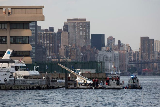 Emergency responders attend to a seaplane that made a hard landing during a failed takeoff along FDR Drive in New York.