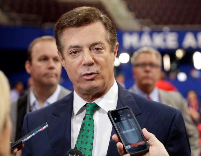 FILE - In this July 17, 2016 file photo, Trump campaign chairman Paul Manafort talks to reporters on the floor of the Republican National Convention at Quicken Loans Arena in Cleveland as Rick Gates listens at back left. President Donald Trump’s eldest son and his former campaign chairman are agreeing to discuss being privately interviewed by a Senate committee investigating Russia’s meddling in the 2016 election. (AP Photo/Matt Rourke, File)