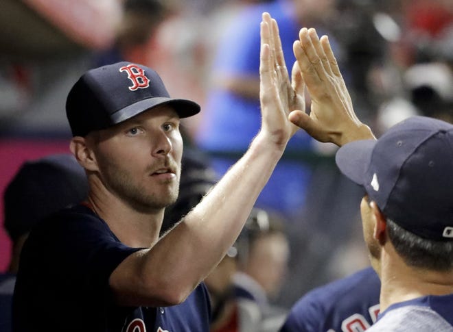 Boston Red Sox starting pitcher Chris Sale is greeted in the dugout after the sixth inning against the Los Angeles Angels Friday. [The Associated Press/Chris Carlson]