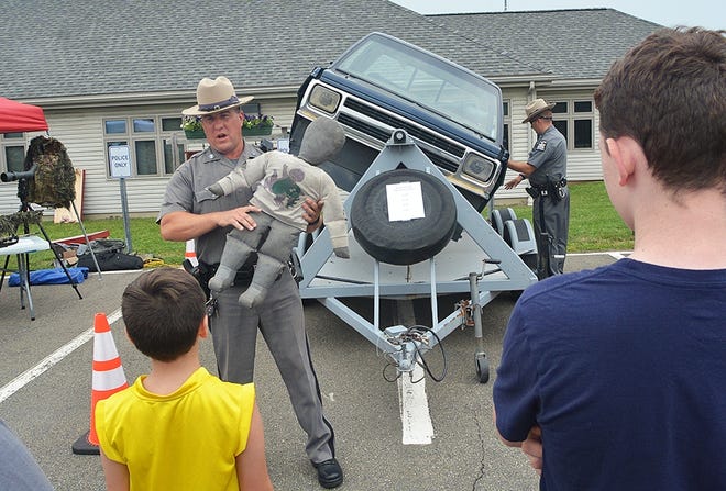 Trooper Steve Gross talks about the affects of a 25 mph rollover by the rollover simulator at the Painted Post State Troopers Barrabcks open house Saturday. [ERIC WENSEL/THE LEADER]