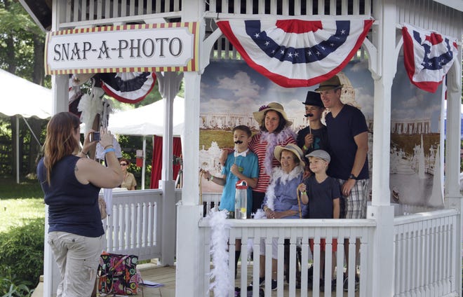 Members of the Horvath family of Cumberland pose with 1904-style photo props for volunteer Lisa Boutin, who was manning the Snap-A-Photo booth at Sunday's Hearthside House Museum annual event. [The Providence Journal / Kris Craig]