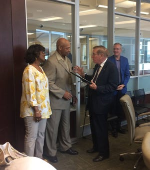 Chatham Area Transit Board Member Pete Liakakis, right, presents James A. Brown Jr. with a proclamation in honor of his recent retirement as Brown’s wife looks on. Brown retired at the end of June after working 42 years with the local transit authority. (Kelly Quimby/Savannah Morning News)