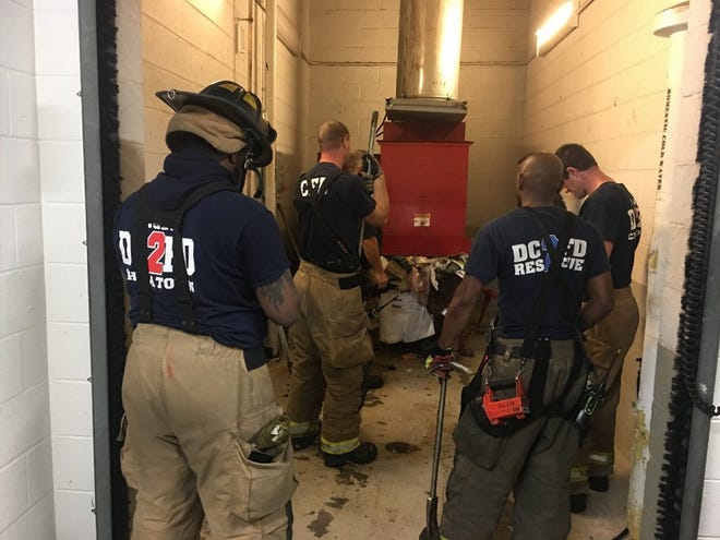 Emergency personnel respond to a call from a man who was stuck in a trash chute on Sunda, in Washington. [Vito Maggiolo/DC Fire and EMS Department via AP]