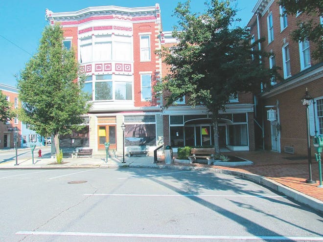 Large yellow auction signs can be seen in the windows of the two buildings on the left in Center Square, Greencastle, that were sold last week for BB&T, at right. The buyer has not been disclosed.