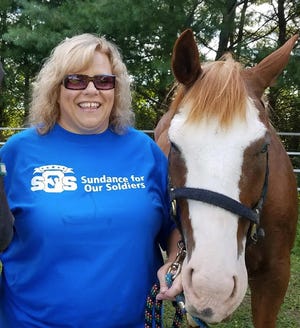 Megan Sundeen is pictured with one of the therapy horses in her Sundance for Our Soldiers program, which provides help for hurting soldiers.