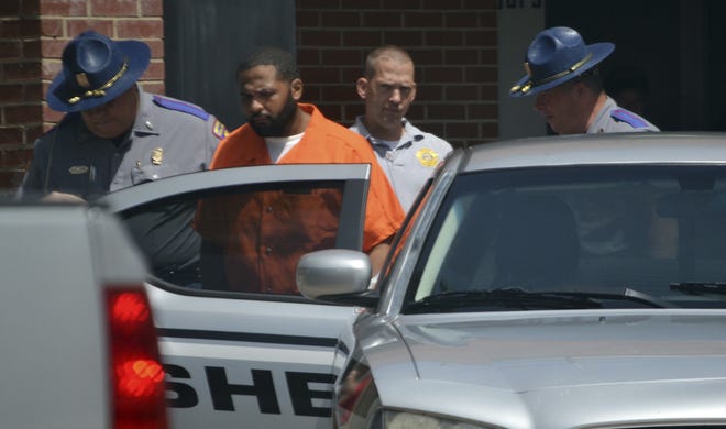 Willie Cory Godbolt, 35, right, is escorted by several lawmen into a waiting Copiah County Sheriff's Department transport vehicle, following a probable cause hearing in court in Brookhaven, Miss., Wednesday. (Donna Campbell/The Daily Leader, via AP)