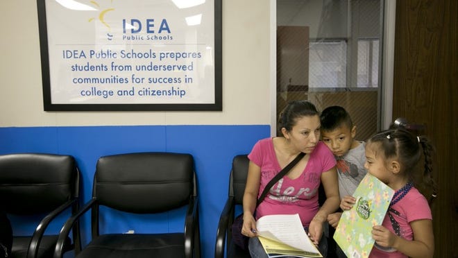 Elena Elias, left, registers her children, Jhon Elias, 6, and Jacqueline Elias, 4, for the 2014-2015 school year at IDEA Allan school in July, 2014. JAY JANNER / AMERICAN-STATESMAN