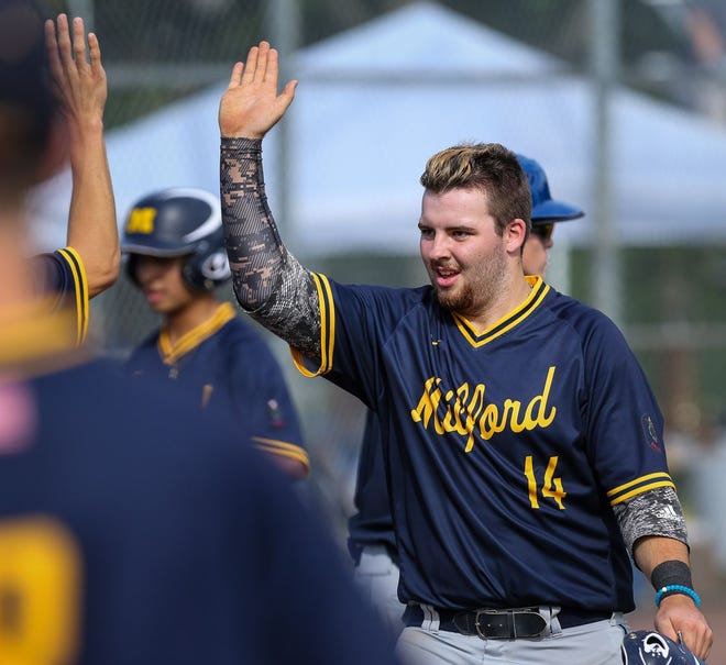 Milford Post 59's Tyler Monahan high-fives teammates after scoring during 8-3 win over Shrewsbury in American Legion state tournament at Fino Field in Milford on Friday. [Daily News and Wicked Local Photo/Dan Holmes]