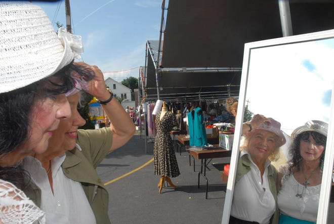 Barbara Silock and Gisell Lindner, both of Stroudsburg try on some hats in the women's apparel section of the Summer Festival at St. Luke's Church in Stroudsburg in 2009. [POCONO RECORD FILE PHOTO]