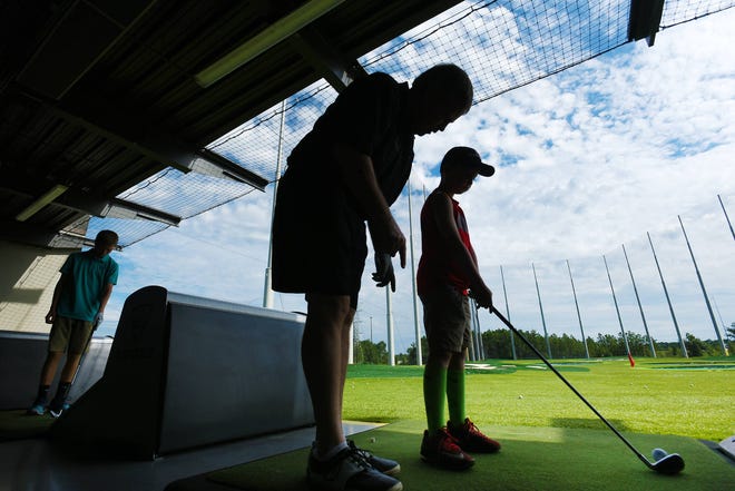 Steve O’Donogue gives instructions to one of his young students at Topgolf earlier this month. (Bob Self/Florida Times-Union)