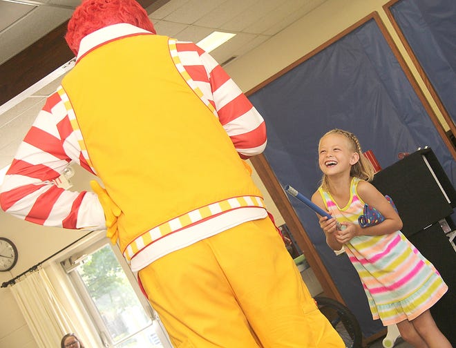Audrey Kroa, 6, of Litchfield, laughs as she help Ronald McDonald perform a magic trick. [ANDY BARRAND PHOTO]