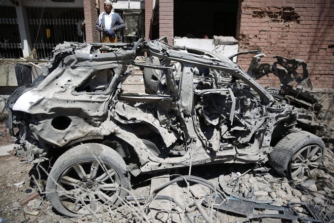 FILE PHOTO: A Yemeni man stands next to a damaged vehicle after an airstrike by Saudi-led coalition in Sanaa, Yemen, Saturday, Feb. 27, 2016.
