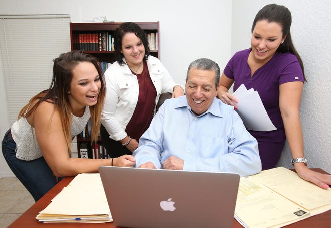 Bernie DeCastro looks over files for the Re-Entry Center of Ocala (RECO) on a laptop with his daughters, Hannah, 20, Olivia, 18, and Noelle, 25, left to right, at their home in northeast Ocala on Wednesday. DeCastro's five children have participated in variety of summer activities, including continuing education, working one or two jobs, and helping out at the center, a ministry for people who have been caught up in the criminal justice system, which he started in 2005. [Bruce Ackerman/Ocala Star-Banner] 2017.
