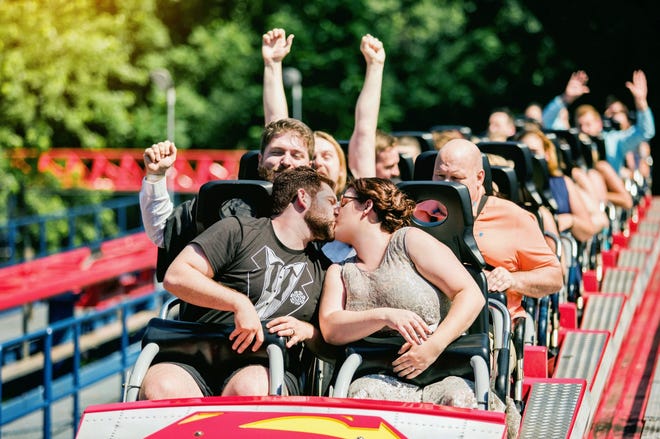 Guests cheer bride and groom Ashley and Thom Marchetti as they kiss on the Superman roller coaster at Six Flags New England in Agawam, Massachusetts. [Courtesy of Thom and Ashley Marchetti]