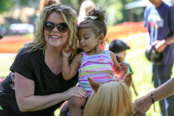 Two-year-old Sofia Watkins poses with her mom, Nina Watkins, during a pony ride at Island Park on Saturday. (Collin Andrew/The Register-Guard)