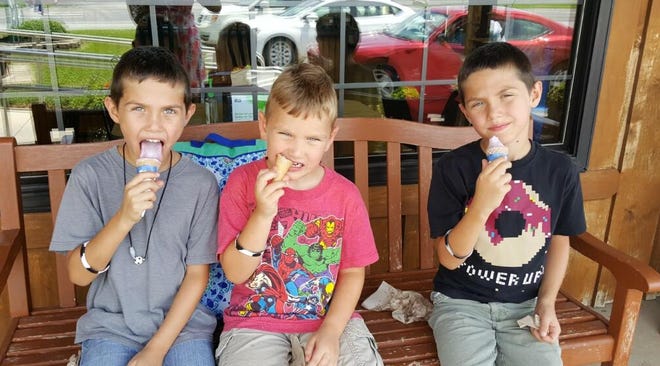 Gavin Parris, 7, Declan Parris, 5, and Keegan Parris, 7, enjoy a tasty treat after a field trip to Trickling Springs Creamery in Chambersburg. The behind-the-scenes tour was part of the summer reading program.