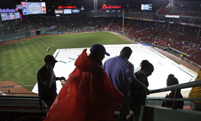 Fans leave Fenway Park after Wednesday night's game between the Red Sox and Indians was cancelled due to heavy rain and thunderstorms. [AP / Charles Krupa]