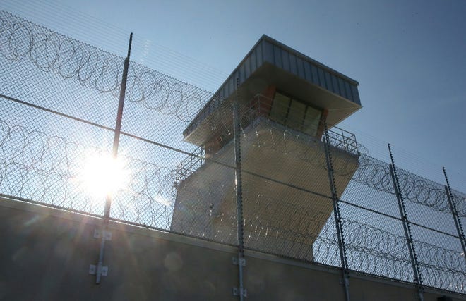 A watchtower and security fence at a maximum security prison in Iowa. [Bryon Houlgrave/The Des Moines Register via AP]
