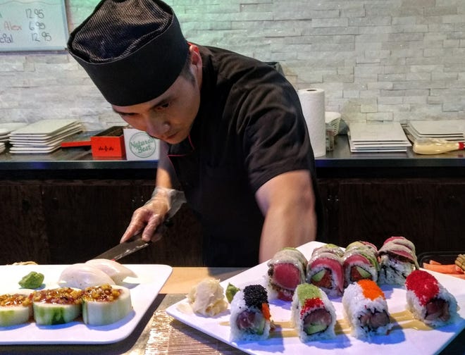 A busy sushi chef with his creations at Sakura.