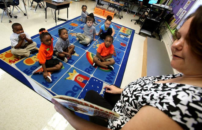 Mary Ledford reads her group of kindergartners a story on the first day of school at Graham Elementary School on Monday. [Brittany Randolph/The Star]