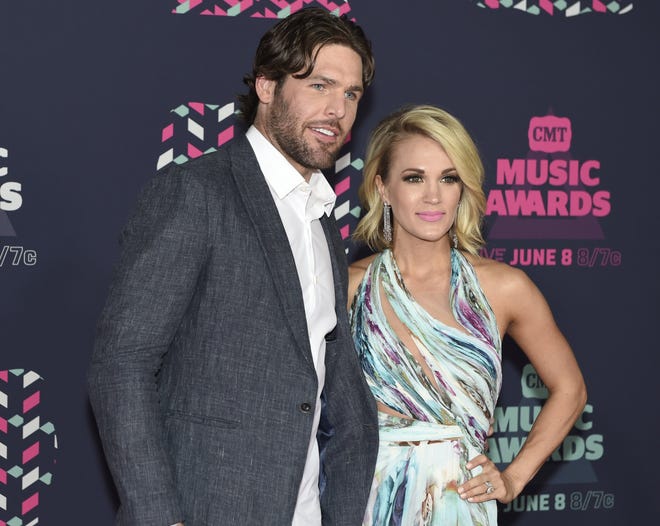 Mike Fisher, left, and wife Carrie Underwood at the 2016 CMT Music Awards. [Photo by Sanford Myers/Invision/AP]