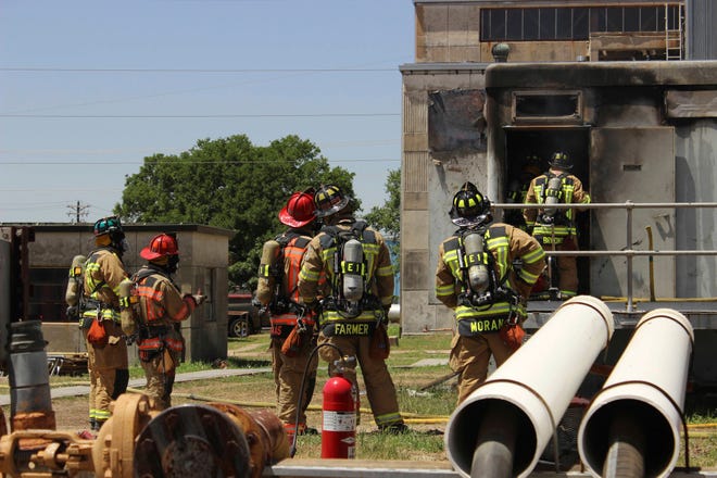 In this photo provide by the Bryan, Texas Fire Department, taken April 29, 2014, Bryan Texas firefighters stand outside the Bryan Texas Utilities Power Plant following an explosion and fire. Earle Robinson, 60, and other employees were doing maintenance work at Bryan Texas Utilities Power Plant, about 100 miles north of Houston, when there was a loud explosion. Workers called 911 and pleaded for help. Older people are dying on the job at a higher rate than workers overall, even as the rate of workplace fatalities decreases, according to an Associated Press analysis of federal statistics. (Bryan, Texas Fire Department via AP)