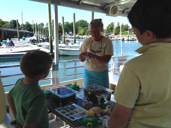 Naturalist Andrea Higgins talks to children at the start of a Barnstable Ecotour Sandbar Exploration cruise. [PHOTO BY MARY RICHMOND]