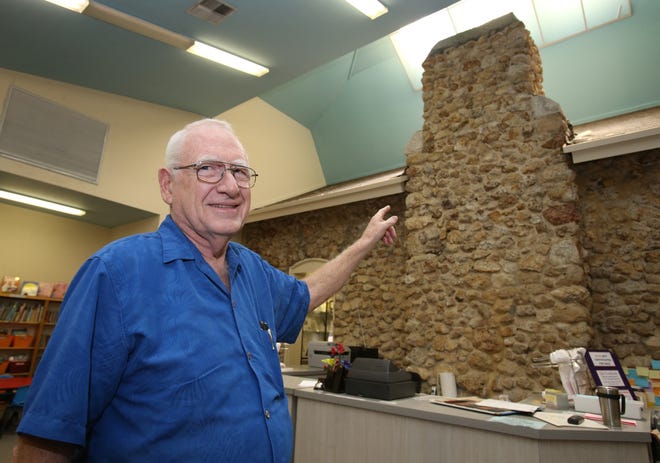Tom Dann, president of the Friends of the Belleview Public Library, points out the chimney and original roofline still visible after the former library building was expanded years ago. The building on Southeast Earp Road in Belleview now houses the Friends-run Book Nook. The venue, built in 1908, also contains a museum. [Bruce Ackerman/Staff photographer]
