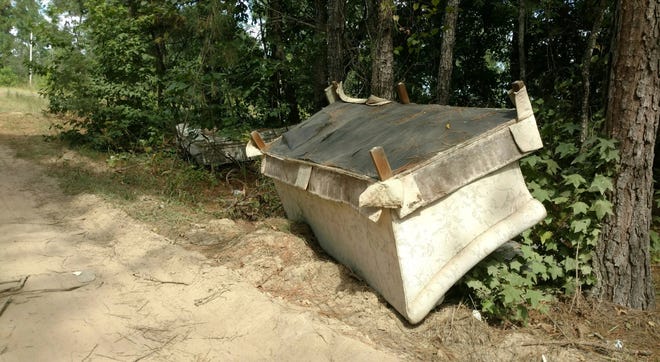 A discarded sofa dumped on a little-used dirt road in Harnett County. Officials are holding an inaugural county-wide cleanup Saturday. [Chick Jacobs/The Fayetteville Observer]
