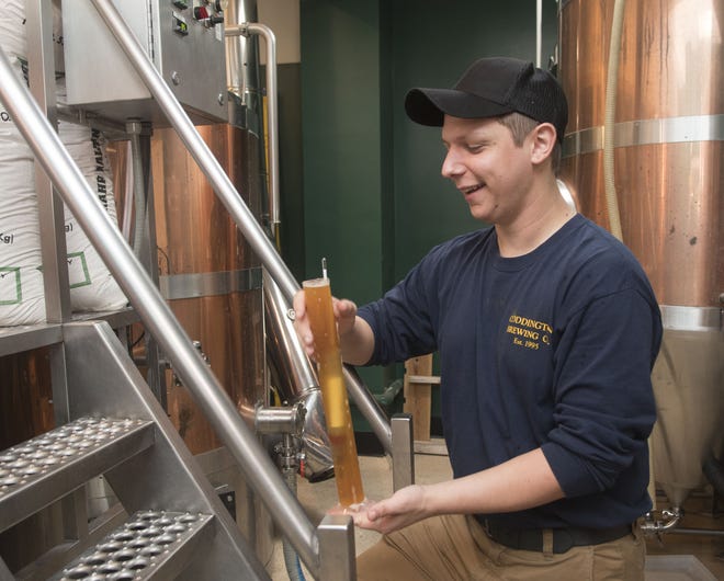 Coddington Brewing Co. head brewer Josh Schilling measures the gravity of an IPA sample recently at the brewery in Middletown. Schilling uses the measurement to calculate the sugar/alcohol content of the beer.