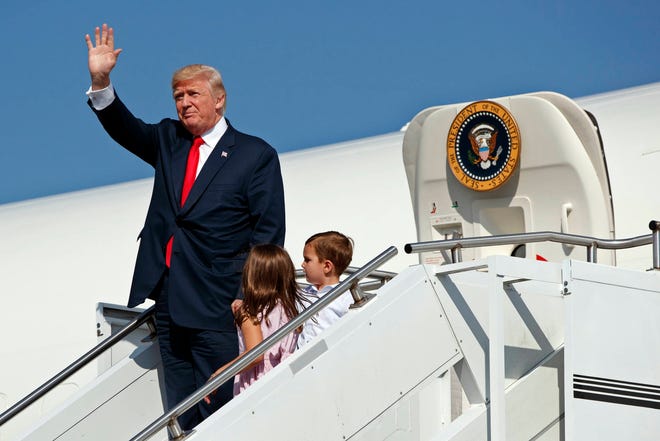 President Donald Trump waves as he walks down the steps of Air Force One with his grandchildren, Arabella Kushner, center, and Joseph Kushner, right, after arriving at Morristown Municipal Airport to begin his summer vacation at his Bedminster golf club, Friday, Aug. 4, 2017, in Morristown, N.J. (AP Photo/Evan Vucci)
