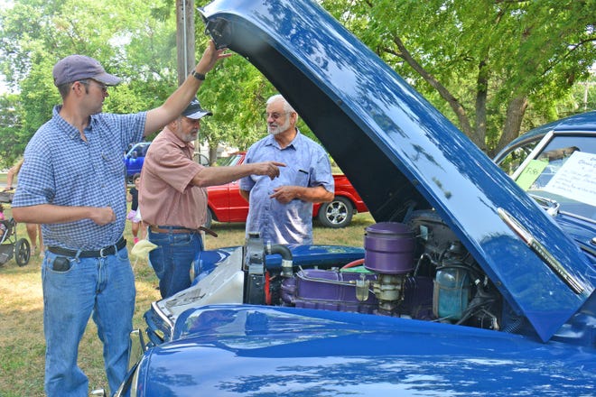 Chris Wallace (left) holds the hood up on his 1947 Chevy Fleetmaster as his father Heinz Wallace visits with Ron Bartel, of Hillsboro, who recently acquired a Chevy Fleetmaster and is working on restoring the body. [PHOTOS BY AARON ANDERS/SALINA JOURNAL]
