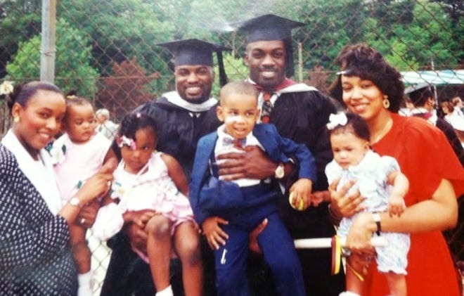 The new principal of West Middle School, Carlton Campbell, fourth from th eleft, is shown at his 1994 Boston College graduation with his wife, Malinda, left, his brother Darnell who also graduated, Darnell's wife, and their children.