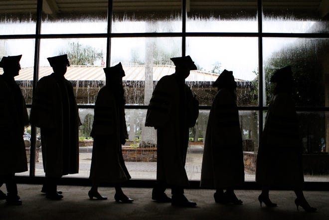 Graduates wait to participate in a commencement. [Rachel S. O’Hara/Herald-Tribune]