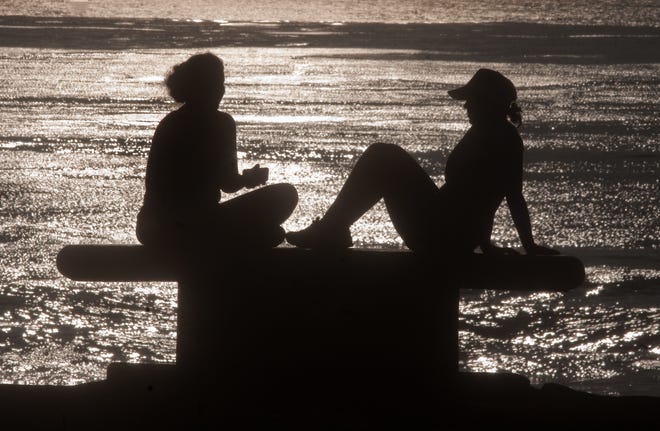 Two women chat while sitting on a bench along the Sunset Cliffs in San Diego. [CLIFFORD OTO/THE RECORD]