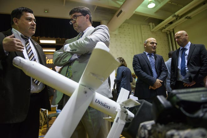 Yossi Gez, left, with Mistral Inc. speaks with Robert Wilkie, at a display for Uvision's defense equipment during the 16th annual N.C. Defense and Economic Development Trade Show August 7, 2017. [Melissa Sue Gerrits/The Fayetteville Observer]