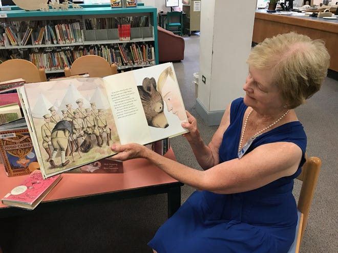 Retiring West Roxbury children’s librarian Gwen Fletcher holds one of her favorite picture books, “Finding Winnie,” by Lindsay Mattick. [Wicked Local staff photo/Julie M. Cohen]