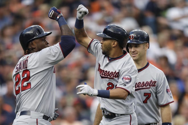 Minnesota Twins' Eddie Rosario, center, is greeted by teammates Miguel Sano (22), and Joe Mauer (7) after his three-run home run during the fourth inning of the team's baseball game against the Detroit Tigers, Friday, Aug. 11, 2017, in Detroit. (AP Photo/Carlos Osorio)