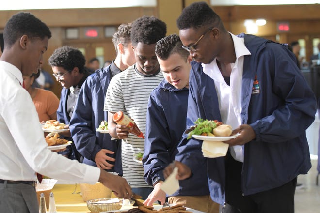 Members of the 100 Males to College program help themselves to dinner at the buffet line during the program's achievement reception Thursday at Worcester State University. [T&G Staff/Steve Lanava]