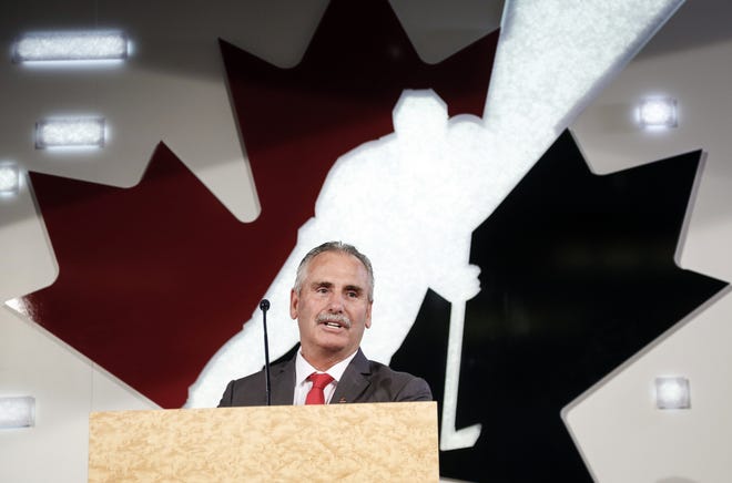 Former Vancouver Canucks head coach Willie Desjardins, who will be Team Canada's head coach for the 2017-2018 season, speaks at a news conference in Calgary, Alberta. The United States and Canada are taking drastically different approaches in the lead-up to the 2018 Olympics without NHL players. [The Canadian Press / Jeff McIntosh via AP, File]