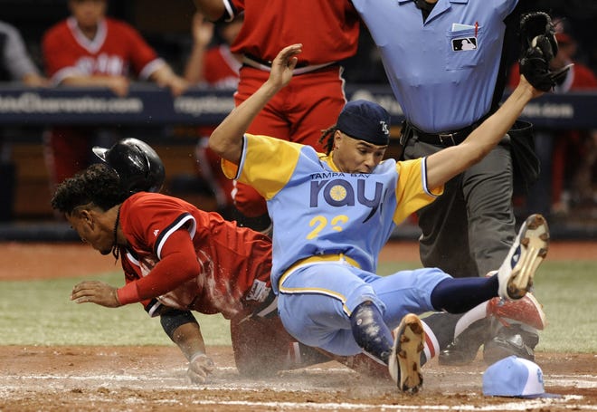 Cleveland's Francisco Lindor, left, scores on a wild pitch from Tampa Bay starter Chris Archer, right, during the third inning on Saturday. Archer was covering the plate on the throw from catcher Wilson Ramos. [STEVE NESIUS/THE ASSOCIATED PRESS]