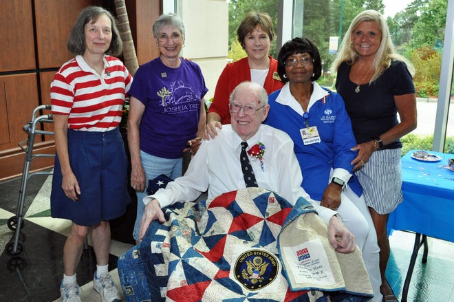 US Army Veteran Tom Kerr displays the quilt awarded to him by the Athens/Oconee Chapter of the Quilts of Valor Foundation. Pictured with Kerr and St. Mary’s Auxiliary President Betty Davenport are Phyllis Rother, Regina Beduhn, Anne Flippen and Kyle Howington. Courtesy St. Mary’s