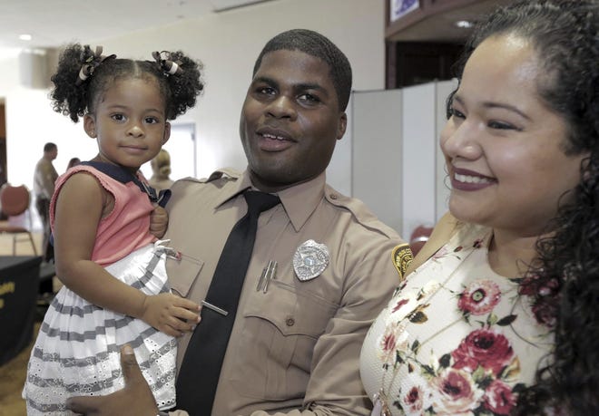 Andre Martin, center, holds his two year-old daughter Ariana on Thursday as his fiance Cynthia Mejia, right, prepares for a a photo in Miami. Martin, a 26-year-old martial arts expert was part of the new graduating class of Miami-Dade police. [JOSE A. IGLESIAS/THE MIAMI HERALD]